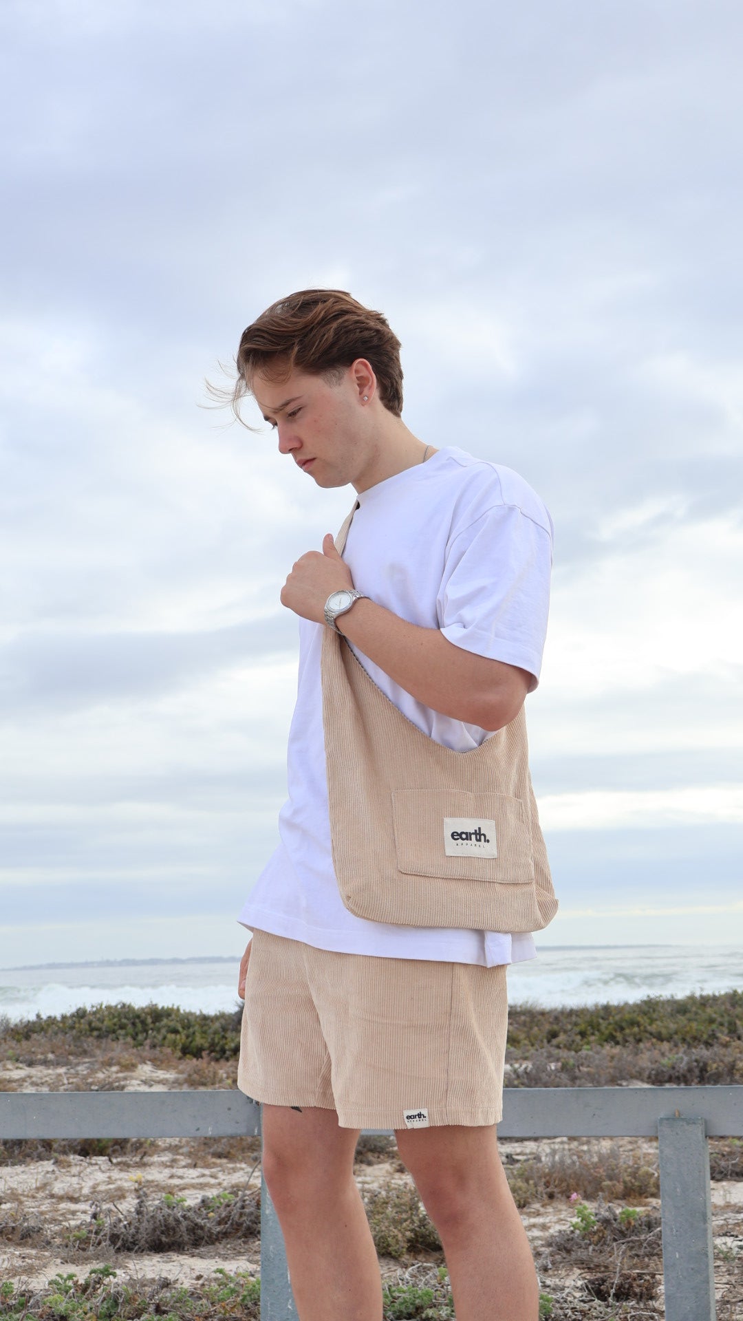 Men's corduroy shorts in earthy tones on model with visible texture, side pockets and elasticated waistband with drawstring.