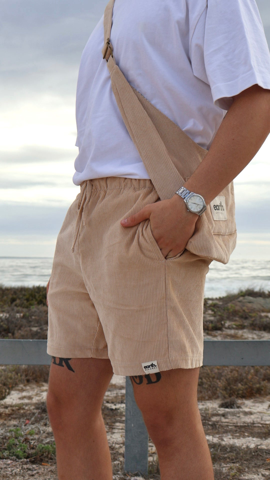 Men's corduroy shorts in earthy tones on model with visible texture, side pockets and elasticated waistband with drawstring.