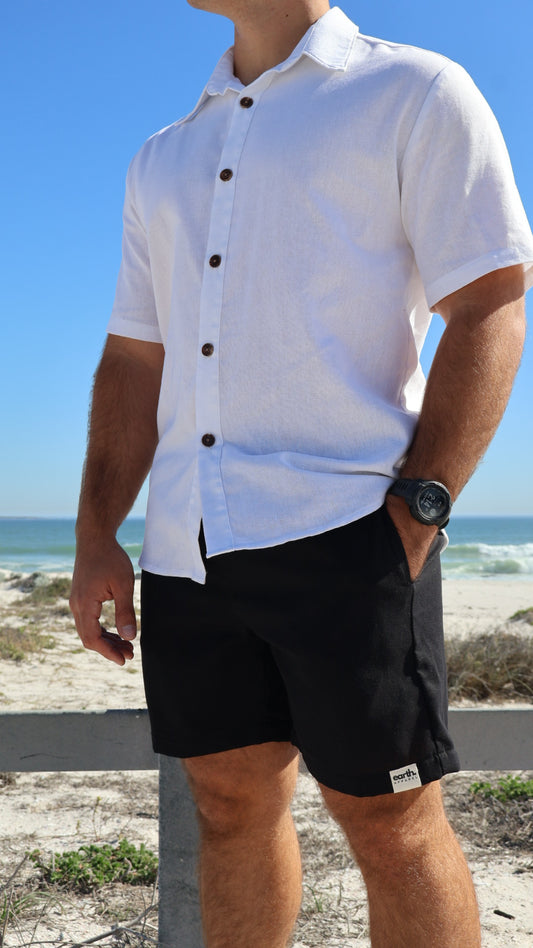 Natural linen men's shorts displayed on model with side pockets and elastic waistband