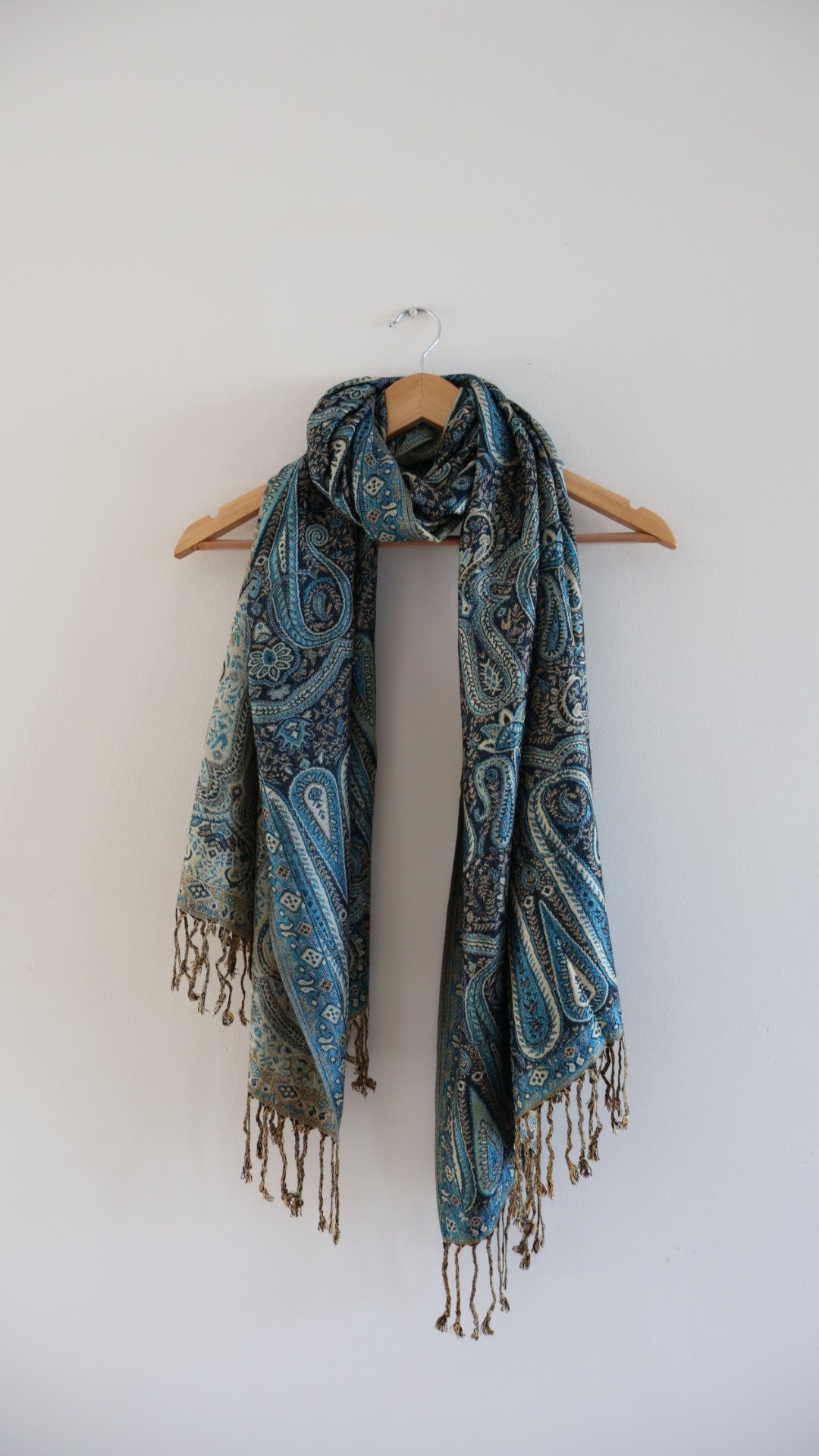 Blue boho festival pashmina scarf draped on a hanger.