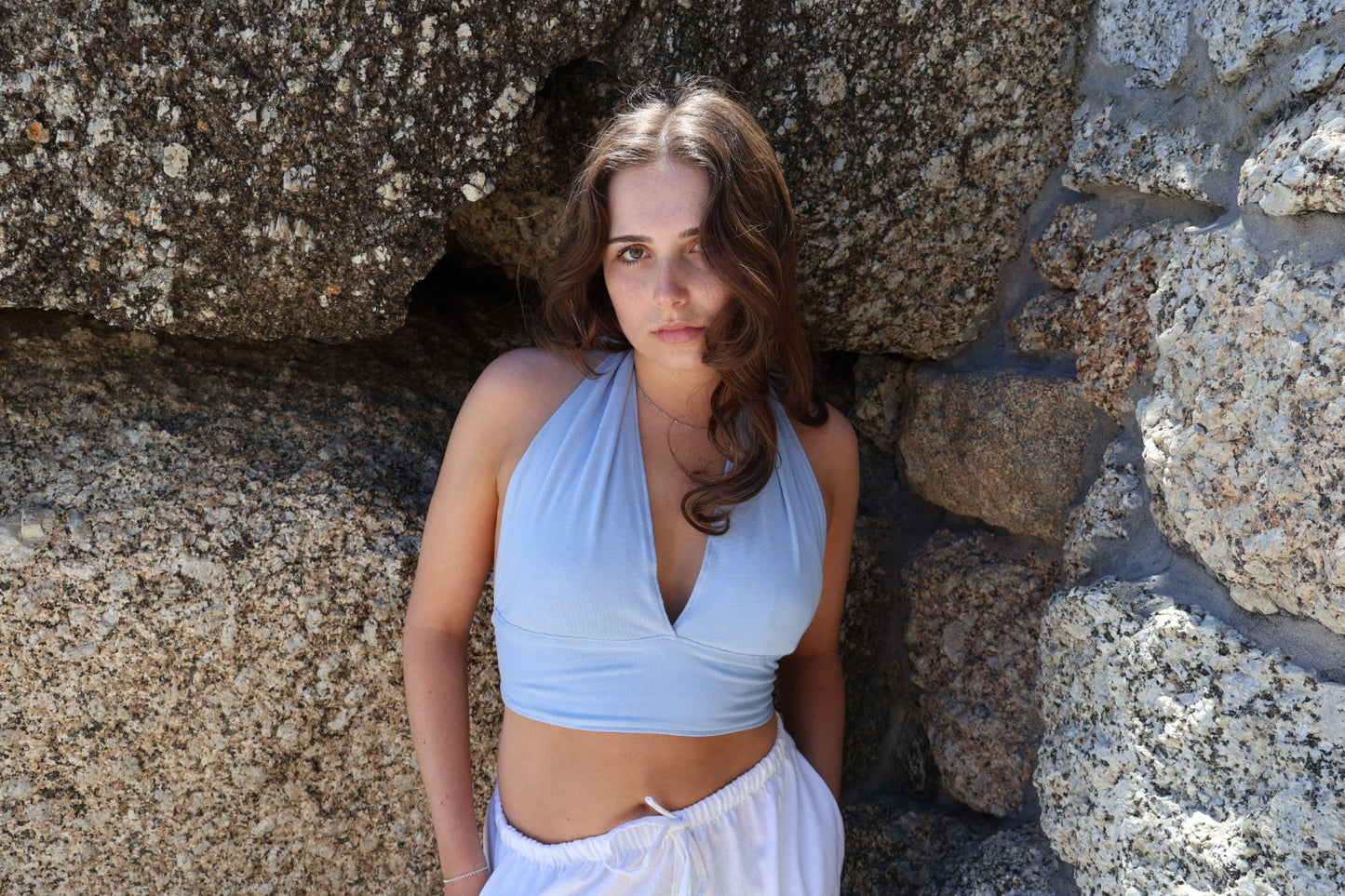 Women's blue halter neck wrap top made from stretchy cotton with a cropped, adjustable fit