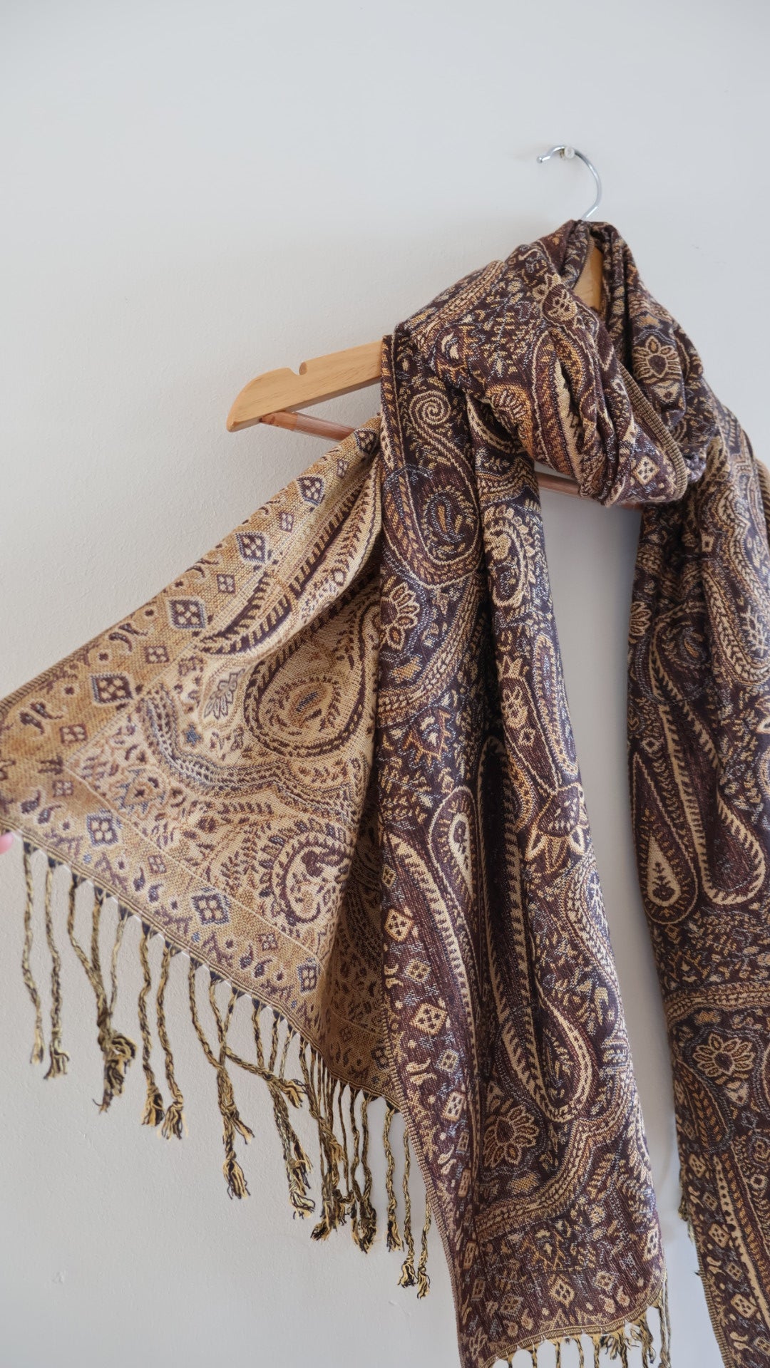 Brown boho festival pashmina scarf draped on a hanger, side 2.