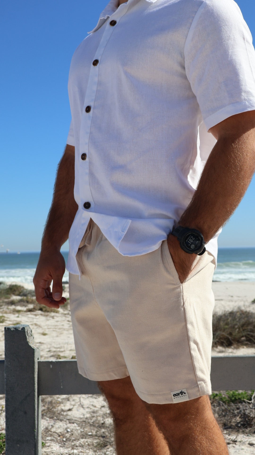 Men's corduroy shorts in earthy tones on model with visible texture, side pockets and elasticated waistband with drawstring.