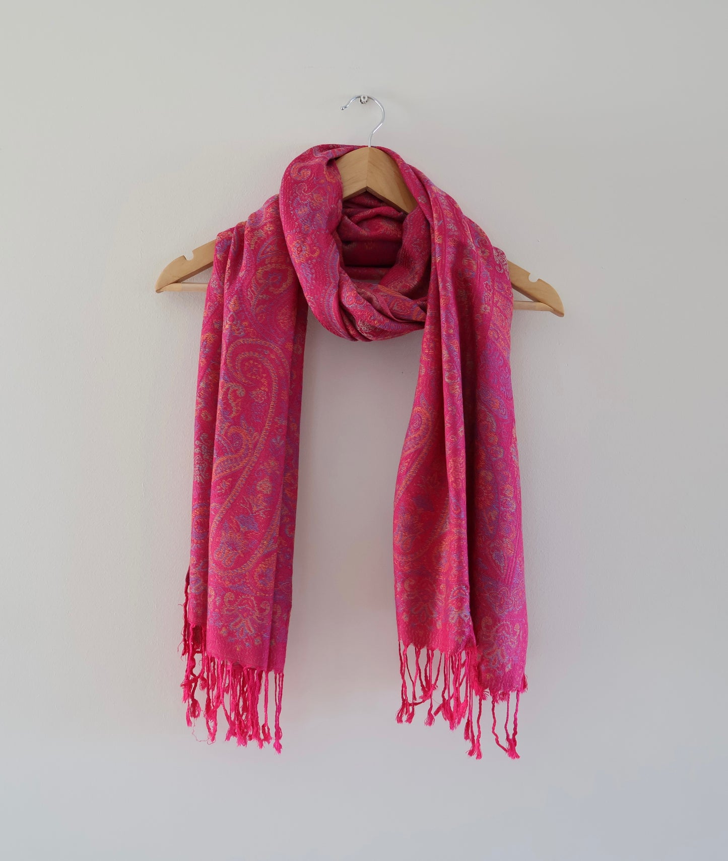 Dark Pink boho festival pashmina scarf draped on a hanger