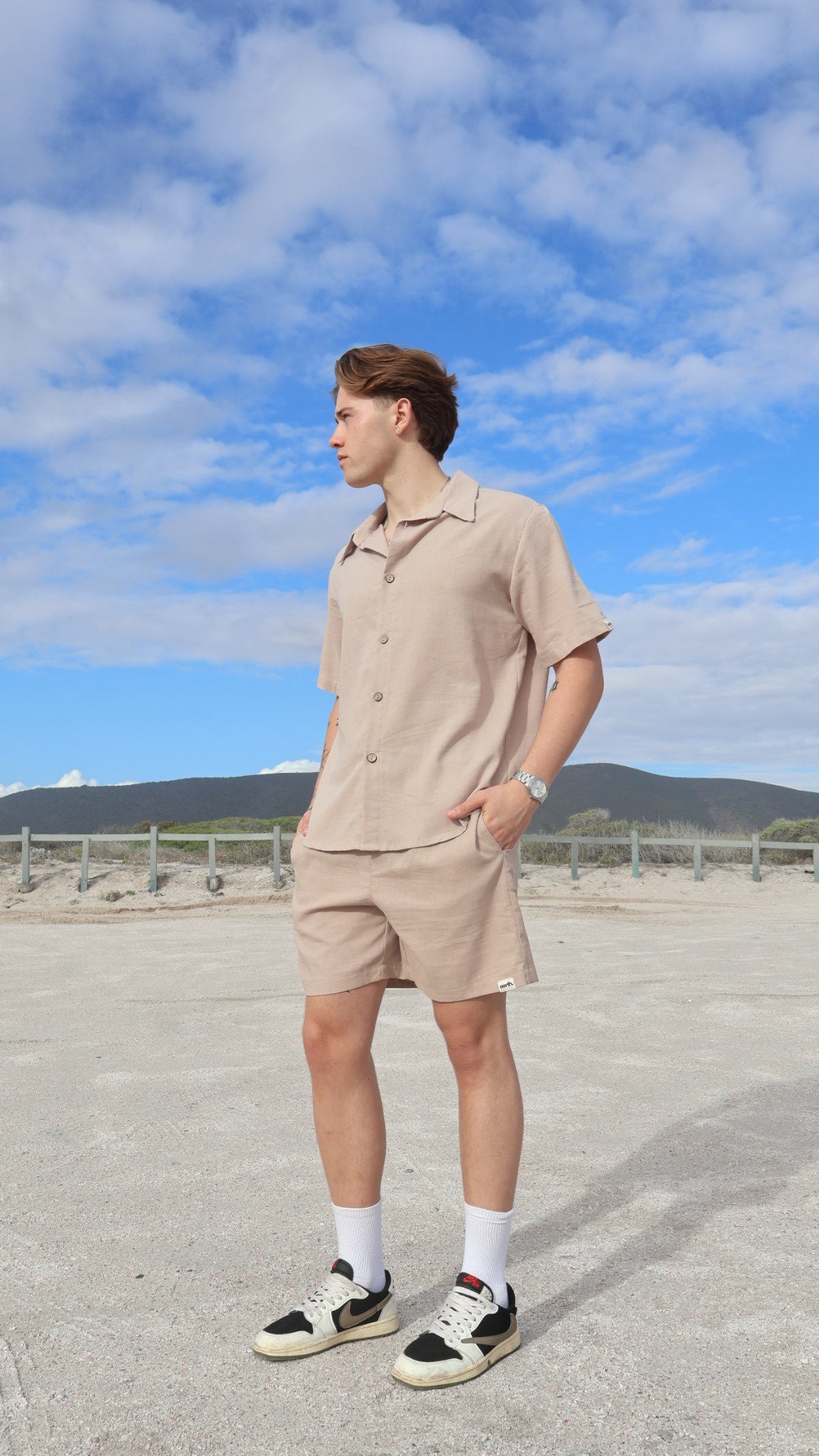 Natural linen men's shorts displayed on model with side pockets and elastic waistband