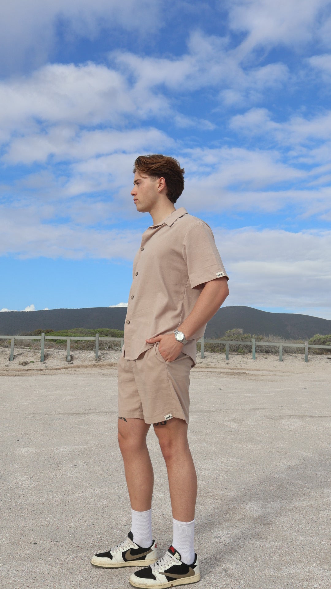 Natural linen men's shorts displayed on model with side pockets and elastic waistband