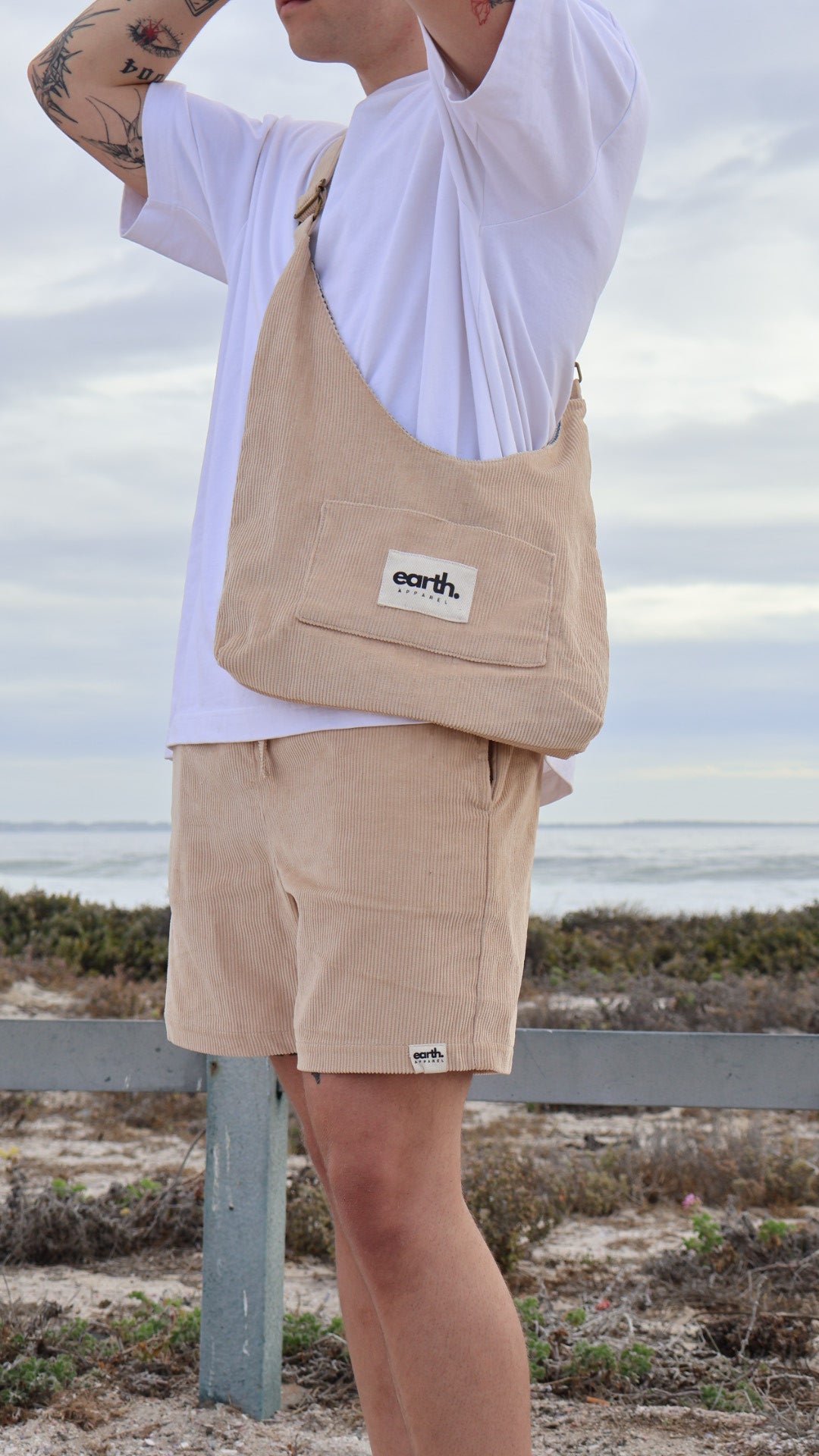 Men's corduroy shorts in earthy tones on model with visible texture, side pockets and elasticated waistband with drawstring.