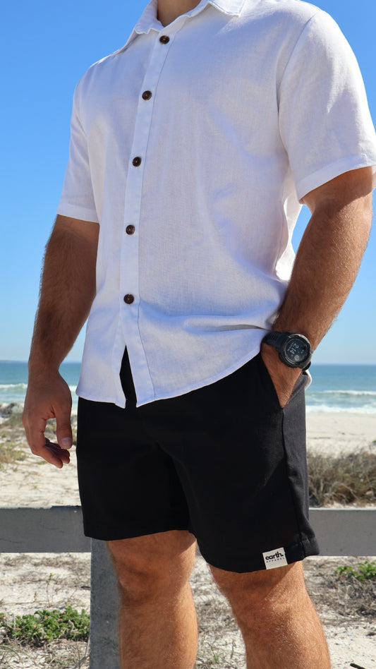 Natural linen men's shorts displayed on model with side pockets and elastic waistband