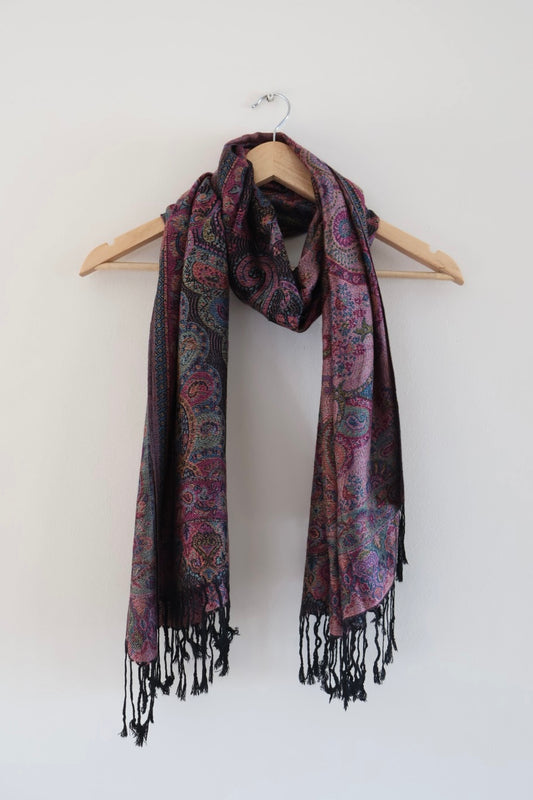 Black and pink boho festival pashmina scarf draped on a hanger
