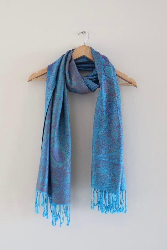 Blue boho festival pashmina scarf draped on a hanger
