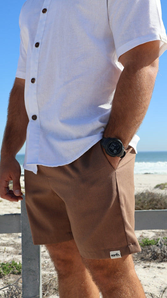 Natural linen men's shorts displayed on model with side pockets and elastic waistband

