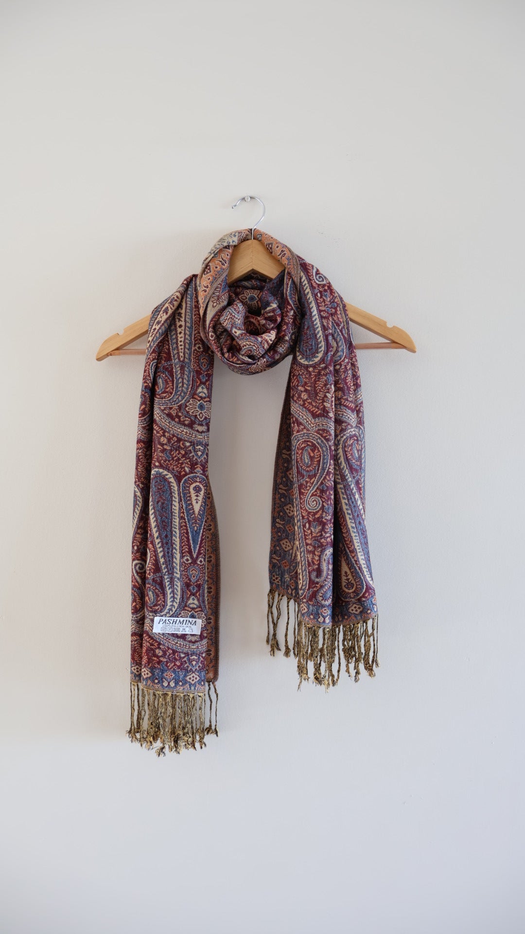 Maroon Blue boho festival pashmina scarf draped on a hanger


