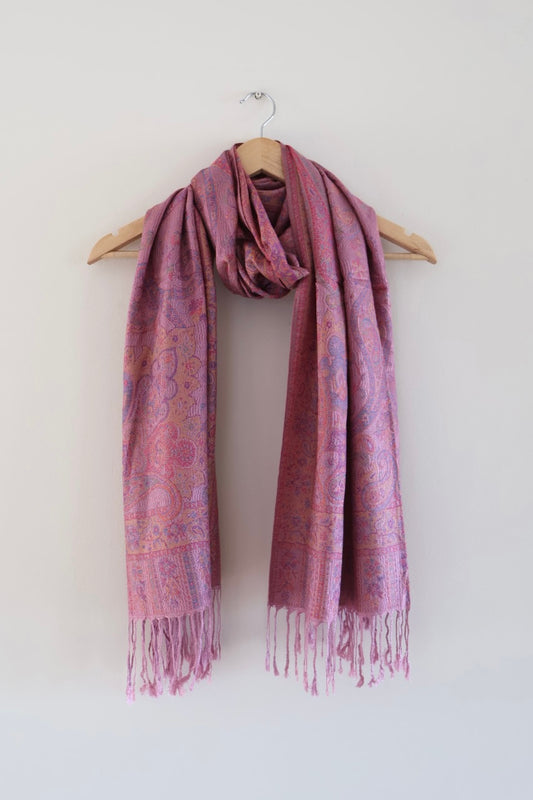 Pink boho festival pashmina scarf draped on a hanger
