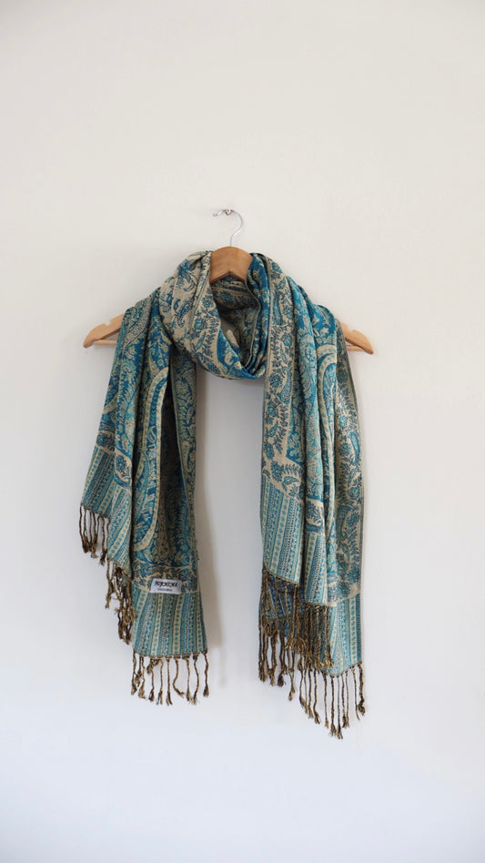Turquoise boho festival pashmina scarf draped on a hanger
